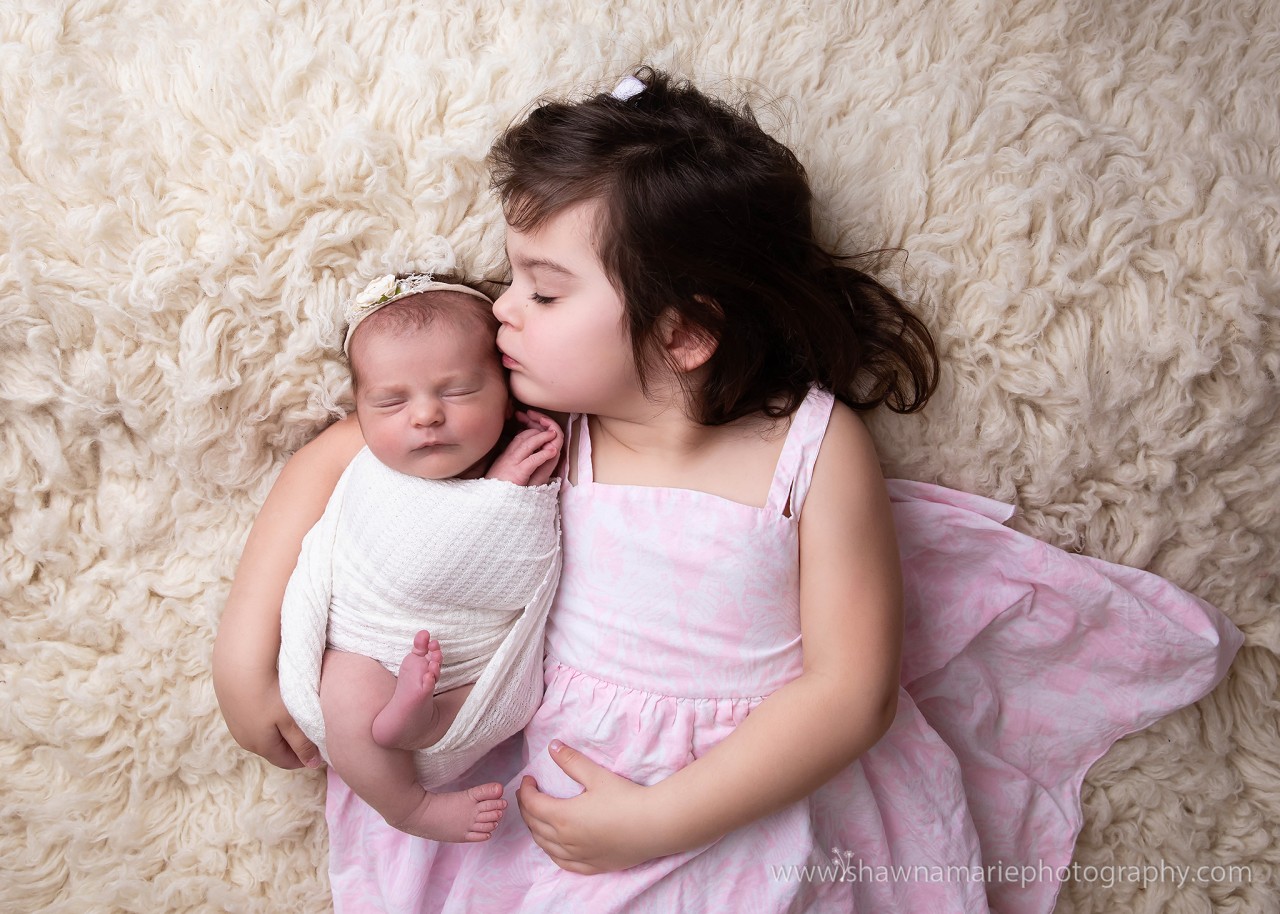 Big sister Ava kisses newborn baby Alivia during studio session - Greenfield Indiana sibling photography